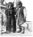 Image of Two Inuit children aboard. 1 in long coat